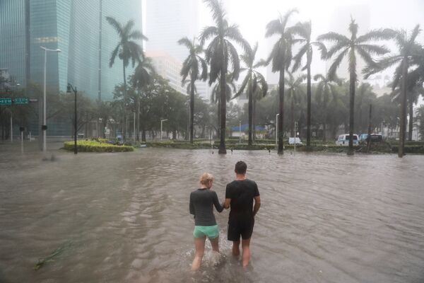 Последствия урагана Ирма во Флориде - люди идут по затопленной улице в квартале Брикелл в Майами - Sputnik Грузия