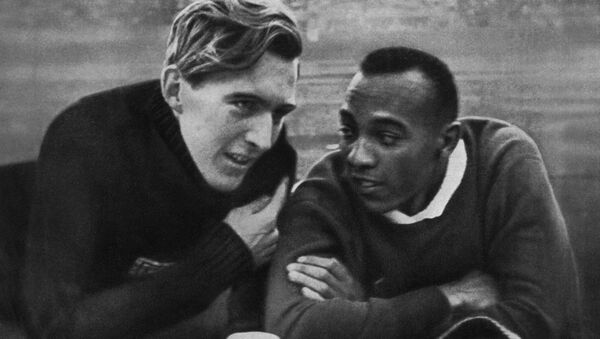 Чемпион США Джесси Оуэнс (справа) и чемпион Германии Лутц Лонг (слева) беседуют на Берлинском стадионе 1 августа 1936 года во время Олимпийских игр, где Оуэнс завоевал четыре золотые медали в беге на 100, 200, 4х100 метров и по прыжкам в длину. Лутц завоевал серебро по прыжкам в длину. Джесси Оуэнс установил шесть мировых рекордов в 1935 году. Установленные Оуэнсом рекорды сохранялись в течение десятилетий. - Sputnik Грузия
