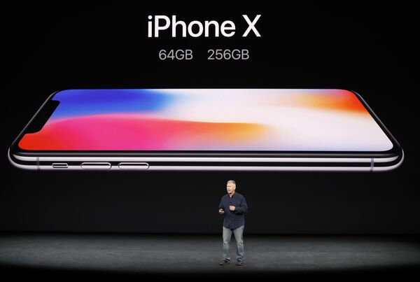 Революционный iPhone X стал главным событием презентации новых смартфонов от Apple. Впервые в дизайне iPhone произошли столь значительные изменения - у телефона отсутствует рамка. Камера сзади повернута на 90 градусов. Телефон полностью водо- и пыленепроницаемый, со стеклянной крышкой и стальными вставками. На фото - вице-президент Apple по маркетингу Фил Шиллер представляет iPhone X на презентации в Купертино, Калифорния - Sputnik Грузия