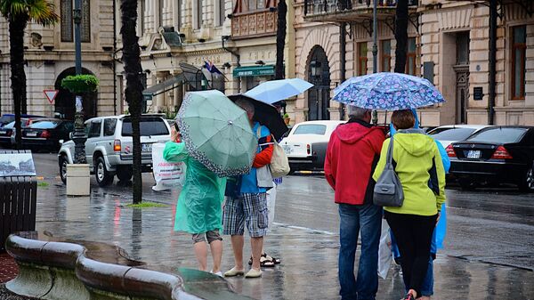 Прохожие с зонтиками идут по одной из улиц Батуми после дождя - Sputnik Грузия