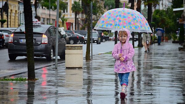 Девочка с зонтиком идет по одной из улиц Батуми после дождя - Sputnik Грузия