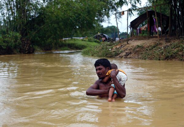 Беженец рохинджа несет ребенка через реку в Бангладеш - Sputnik Грузия