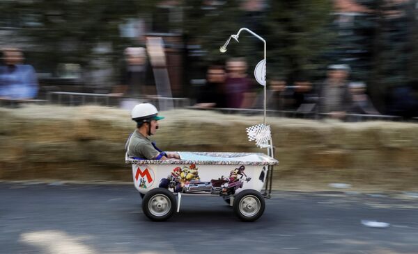 Спортсмен управляет своим самодельным транспортным средством без двигателя во время гонки Soapbox Red Bull в Алматы, Казахстан - Sputnik Грузия
