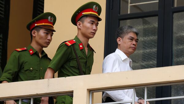 Бывший председатель PetroVietnam Нгуен Суан Шон сопровождается полицией, когда он покидает суд после заседания вердикта в Ханое, Вьетнам - Sputnik Грузия