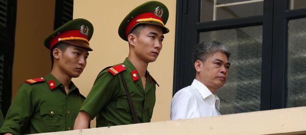 Бывший председатель PetroVietnam Нгуен Суан Шон сопровождается полицией, когда он покидает суд после заседания вердикта в Ханое, Вьетнам - Sputnik Грузия
