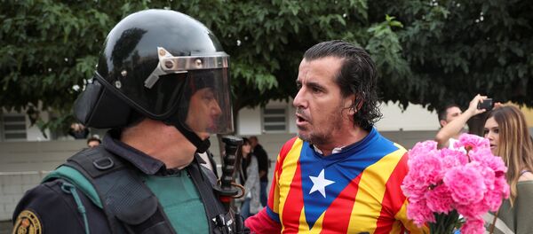 Человек, одетый в рубашку с каталонским флагом и держащий гвоздики, сталкивается с испанским офицером гражданской гвардии за пределами избирательного участка для референдума о независимости в Сант-Джулиа-де-Рамис - Sputnik Грузия