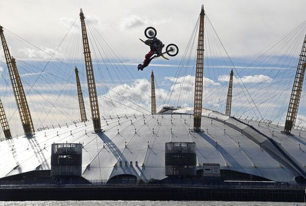 Спортсмен Трэвис Пастрана совершает трюки на своем мотоцикле во время прыжка между двумя баржами на Темзе в Лондоне - Sputnik Грузия