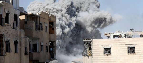 Дым поднимается на позиции боевиков исламского государства после авиационного удара со стороны коалиционных сил возле стадиона в Ракке, Сирия - Sputnik Грузия