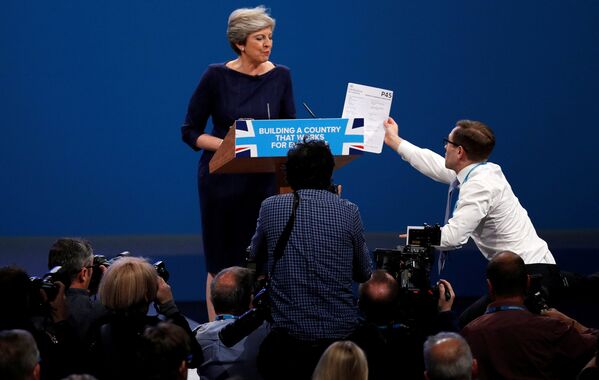 Пранкер передает форму P45 (налоговая форма при увольнении) премьер-министру Великобритании Терезе Мэй, выступающей на конференции Консервативной партии в Манчестере - Sputnik Грузия