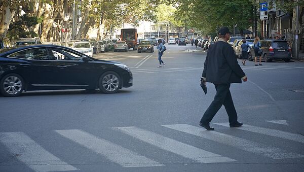 Люди переходят дорогу по зебре на регулируемом перекрестке со светофором - Sputnik Грузия