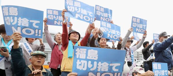 Истцы, которые подали в суд на TEPCO и японское правительство, демонстрируют плакаты перед окружным судом Фукусимы в Фукусиме, Япония - Sputnik Грузия