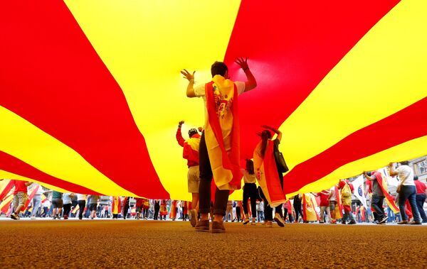 Люди несут огромный флаг Каталонии во время Национального дня Испании в Барселоне - Sputnik Грузия