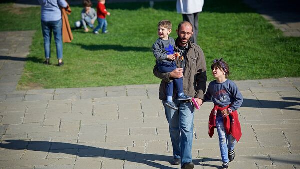 Мужчина идет с детьми по территории храма Светицховели - Sputnik Грузия