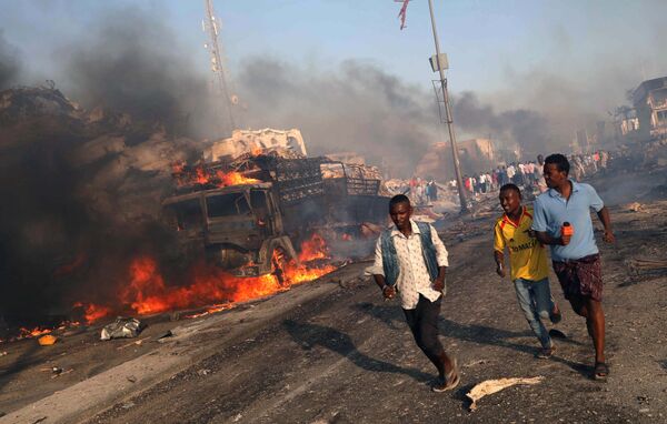 В Могадишо, Сомали произошел сильный взрыв на одной из улиц. На фото - люди бегут с места ЧП - Sputnik Грузия