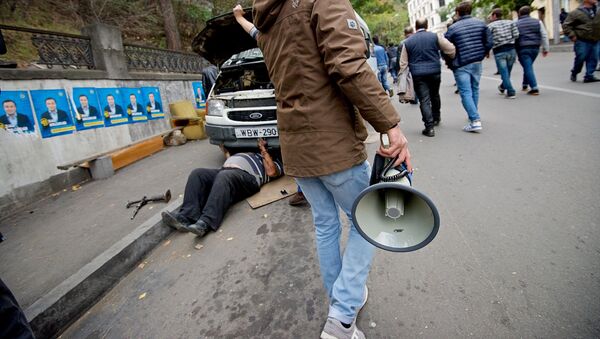 Участник шествия оппозиции идет по улице с мегафоном - Sputnik Грузия