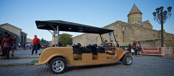 Прогулочный электромобиль на фоне храма Светицховели в городе Мцхета - Sputnik Грузия