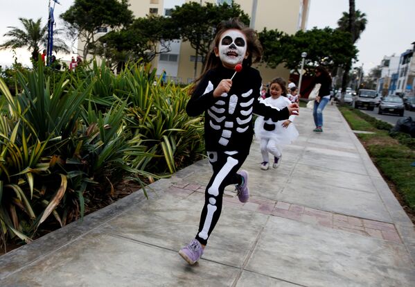 По улицам города Лима в Перу во время празднования Хэллоуина бегали дети в устрашающих нарядах - Sputnik Грузия