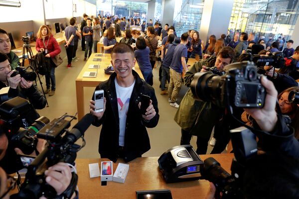 Первый покупатель показывает свой новый iPhone X в магазине Apple Store в Пекине, Китай - Sputnik Грузия