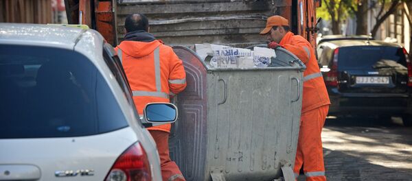Мусорщики катят мусорный контейнер к мусорной машине - Sputnik Грузия