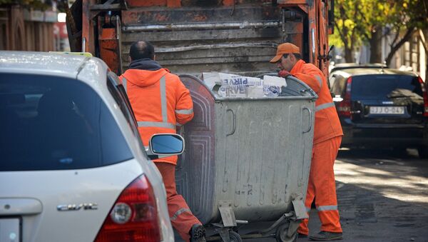 Мусорщики катят мусорный контейнер к мусорной машине - Sputnik Грузия