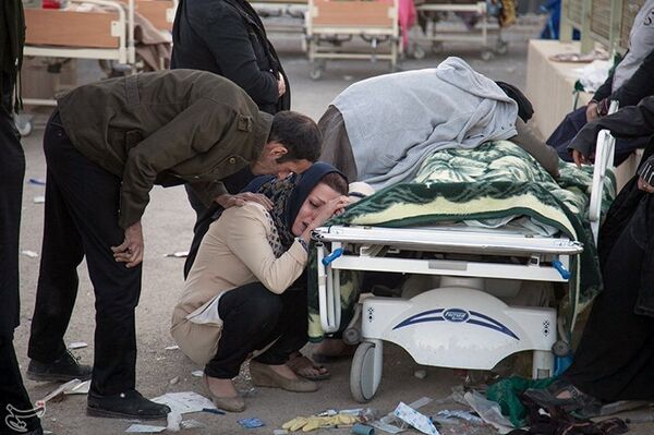 Женщина плачет у тела своего погибшего родственника в городе Сарпол-е Захаб в Иране - Sputnik Грузия
