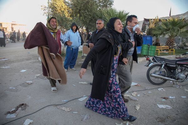 Тысячи семей после землетрясения остались без крова над головой. На фото - люди идут по улицам города Сарпол-е Захаб в Иране - Sputnik Грузия