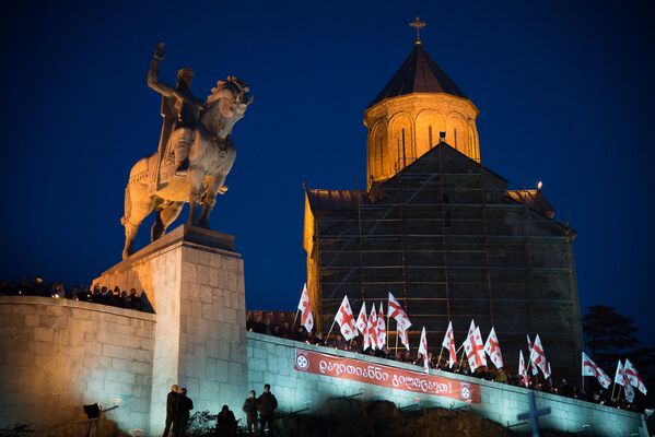 К историческому месту горожане приносят с собой цветы и свечи, а Патриарх всея Грузии и священнослужители проводят молебен в память о мучениках. К Метехскому мосту приносят икону ста тысяч мучеников - Sputnik Грузия
