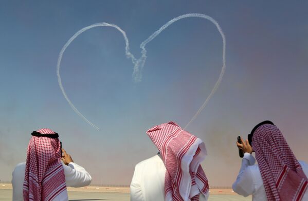 Зрители фотографируют пилотажную команду Аль-Фурса Военно-воздушных сил Объединенных Арабских Эмиратов во время Дубайского авиашоу - Sputnik Грузия