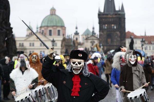 Люди в масках маршируют через Карлов мост в рамках празднования 28-й годовщины Бархатной революции в Праге, Чехия - Sputnik Грузия