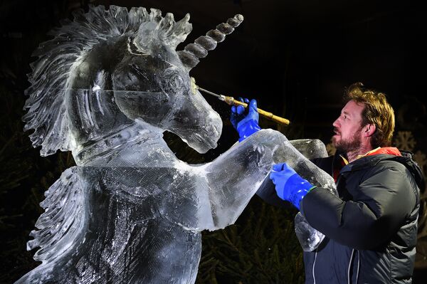 Скульптор Даррен Джексон заканчивает ледяную скульптуру Единорога во время выставки Ледяное приключение: путешествие через замерзшую Шотландию - Sputnik Грузия