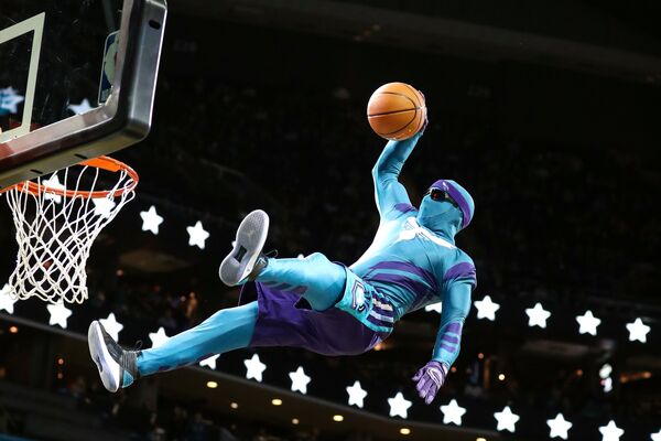 Баскетболист Charlotte Hornets, одетый в костюм талисмана команды, во время перерыва в матче с LA Clippers забрасывает мяч в корзину в зале Spectrum Center. Шарлотт, США - Sputnik Грузия