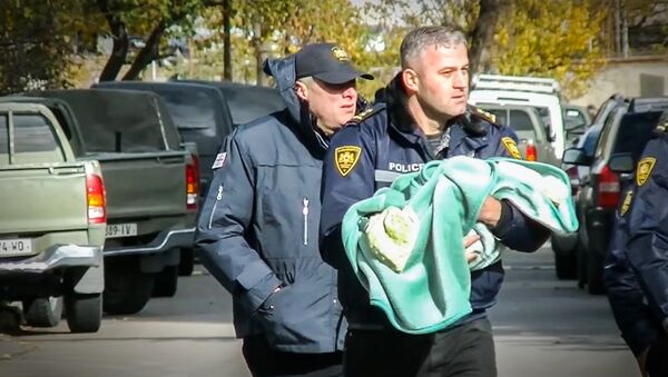 Спецназовец выносит ребенка из зоны спецоперации в Тбилиси - Sputnik Грузия