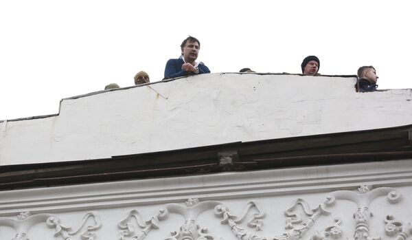 Все началось с того, что в квартиру к Саакашвили пришла полиция с целью его задержания, а политик взобрался на крышу дома, откуда воззвал к своим сторонникам - Sputnik Грузия