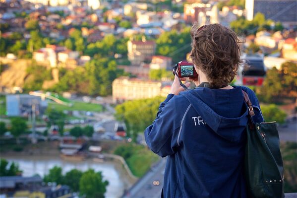 Туристка фотографирует Тбилиси на смартфон со смотровой площадки у верхней станции канатной дороги - Sputnik Грузия