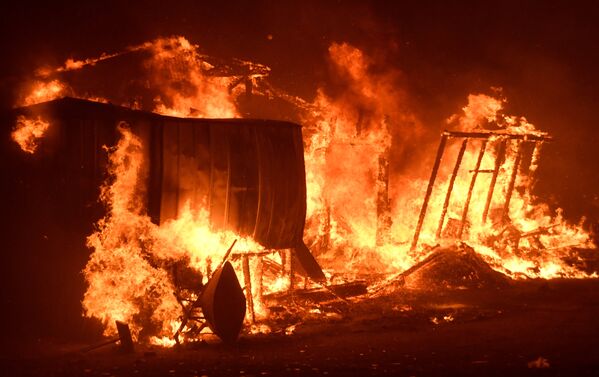 Пожары также бушуют в Лос-Анджелесе, где пламя охватило около 13 тыс акров (5,2 тысячи гектаров) и разрушило более 30 строений, от огня пострадали районы Санта-Кларите и Сан-Бернардино - Sputnik Грузия