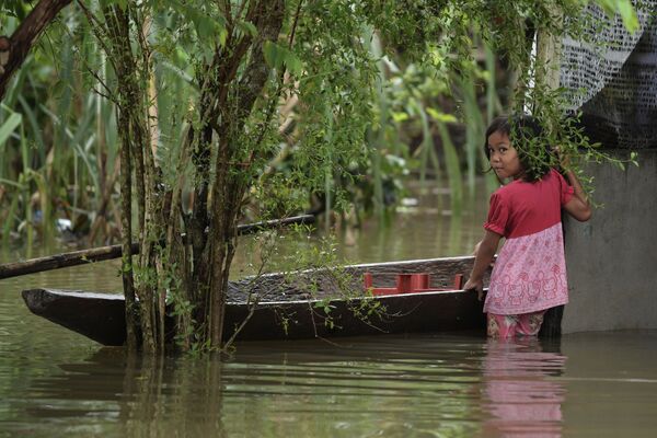Ребенок с лодкой во время наводнения в Малайзии. В результате стихийного бедствия пострадали более 15 тысяч человек. Снимок сделан 6 января 2017 года - Sputnik Грузия