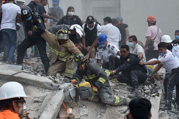 Спасатели работают на месте обрушившегося здания в результате землетрясения в Мехико. Снимок сделан 19 сентября 2017 года - Sputnik Грузия
