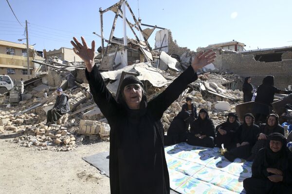 Женщина у разрушенного в результате землетрясения дома на западе Ирана. Фото сделано 14 ноября 2017 года - Sputnik Грузия