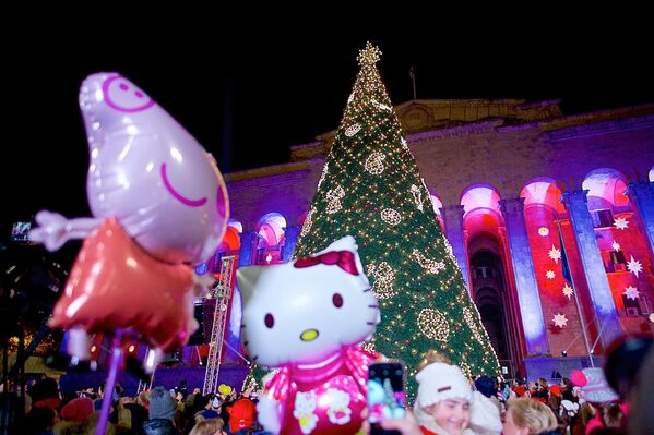 Сотни жителей Тбилиси вместе с детьми собрались на проспекте Руставели у здания парламента, чтобы увидеть включение огней на большой новогодней елке - Sputnik Грузия