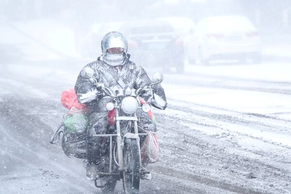 В Китае наступил сезон дасюэ или большого снега. На фото -  мотоциклист едет по заснеженной дороге в Даляне, провинция Ляонин, Китай - Sputnik Грузия