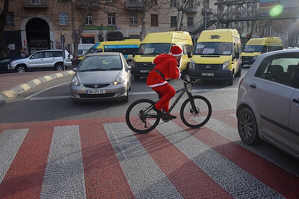 Санта-Клаусы на велосипедах создавали новогоднее настроение не только у пешеходов, но и у водителей машин - Sputnik Грузия