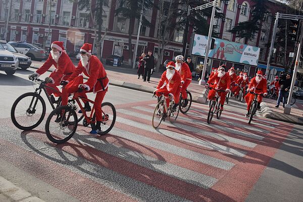 Велосипедисты в костюмах Санта-Клаусов выезжали и на другие улицы в Сабурталинском районе, прилегающие к улице Пекина - Sputnik Грузия