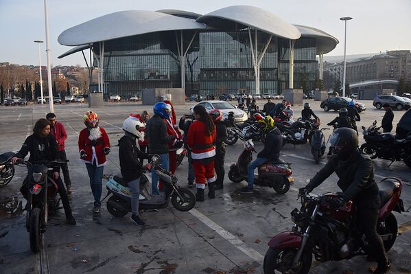 На парковке собралось несколько десятков человек, часть из которых были одеты в костюмы Санта Клаусов - Sputnik Грузия