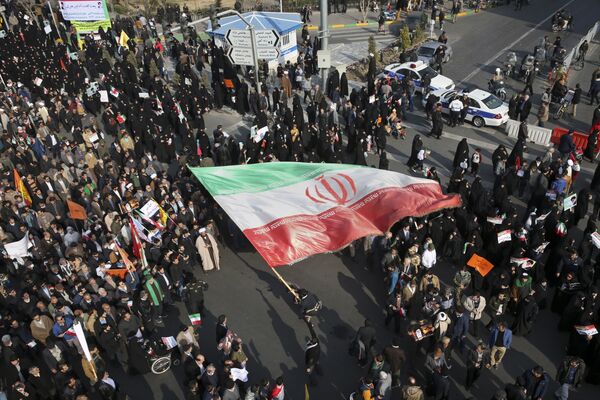 В то же время в Иране проходят и про-правительственные акции в поддержку властей и Роухани. На фото - один из демонстрантов держит иранский флаг в ходе митинга в городе Машхад - Sputnik Грузия