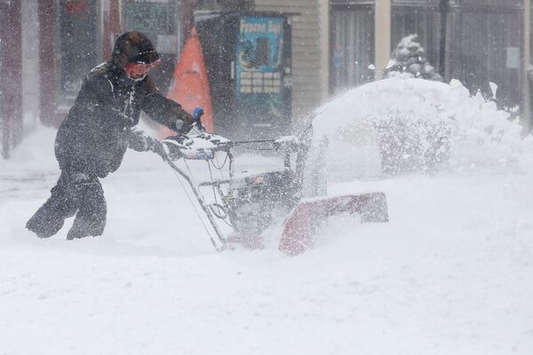 Человек с помощью снегоочистителя прокладывает себе путь по одной из улиц в Порт-Вашингтон, Нью-Йорк, США - Sputnik Грузия