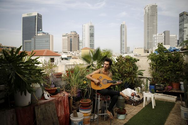 Молодой музыкант Яр Шемель в своем саду на крыше, где он и два его товарища по квартире в Тель-Авиве выращивают травы и овощи - Sputnik Грузия