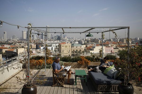 Пожилая пара отдыхает на террасе на крыше своего дома в Тель-Авиве. Дизайн крыши специально по их заказу спроектировал ландшафтный дизайнер - Sputnik Грузия