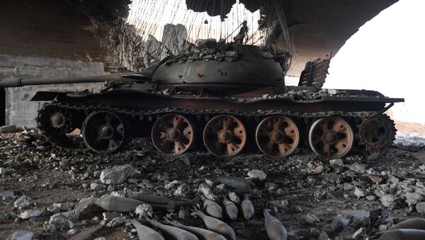 Сожженный танк у военного аэропорта Абу-Духур в провинции Идлиб после боев, в ходе которых сирийская армия восстановила контроль над данным районом - Sputnik Грузия