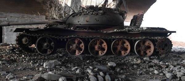 Сожженный танк у военного аэропорта Абу-Духур в провинции Идлиб после боев, в ходе которых сирийская армия восстановила контроль над данным районом - Sputnik Грузия