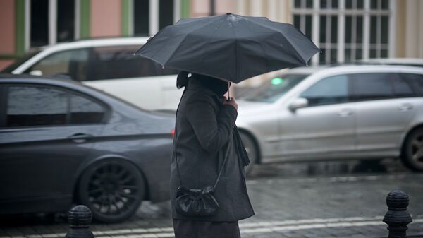 Женщина с зонтиком идет по одной из тбилисских улиц - Sputnik Грузия